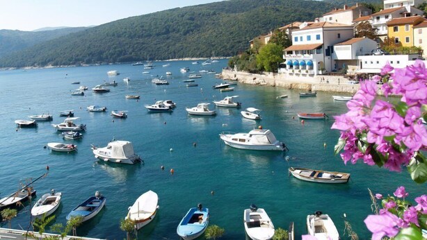 A coastal town with numerous boats docked along the shore, surrounded by buildings and hills. - Vila Pavincica with swimming pool, soccer pitch and award-winning honey tasting (LABIN)