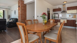 A modern kitchen with dark wooden cabinets, a stainless steel range hood, and a tiled backsplash. - Vila Pavincica with swimming pool, soccer pitch and award-winning honey tasting (LABIN)