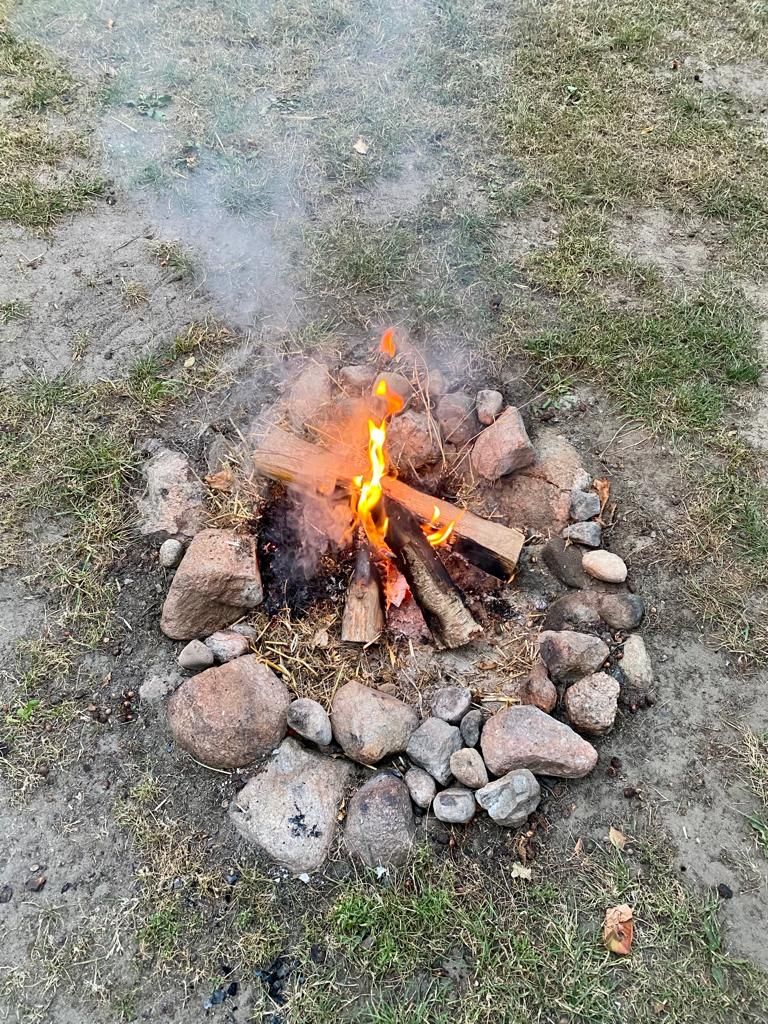 Una fogata rodeada de rocas y troncos.