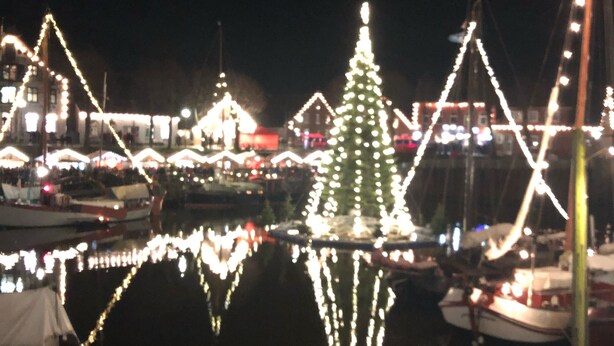 A marina at night with boats docked and illuminated by string lights.