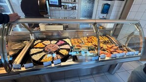 Een buffet met diverse gerechten en prijslabels.