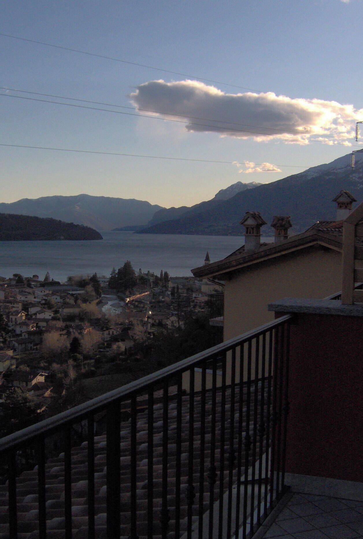 A balcony with a view of a lake and mountains.