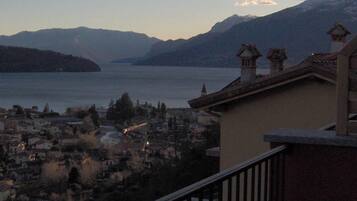 A balcony with a view of a lake and mountains.