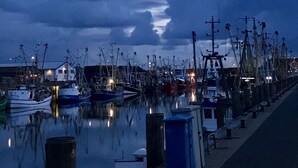 Un port esportiu amb embarcacions amarrades, un passeig marítim i un cel cobert de núvols.
