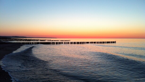 A pier extending into calm waters at sunset. - Beautiful apartment! 250 m to the Baltic Sea beach. Standing vacation, short trip or mobile working. (Börgerende-Rethwisch)