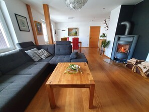 A living room with a sofa, a wooden coffee table, a fireplace, and a painting on the wall.