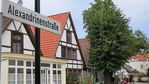 A traditional half-timbered building with a sign reading "Alexandrinenstrae". - Comfortable 4-star roof terrace apartment, quiet and central, 4 adults + 1 baby (Rostock)