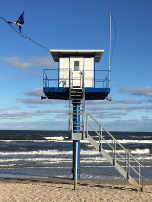 A lifeguard tower with a metal staircase leading up to a blue and white structure, overlooking the ocean. - RESIDENZ-MEERESRAUSCHEN vacation apartment with sauna directly on the beach - pure relaxation (Heringsdorf)