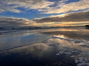 A beach with wet sand and gentle waves, under a partly cloudy sky. - RESIDENZ-MEERESRAUSCHEN vacation apartment with sauna directly on the beach - pure relaxation (Heringsdorf)