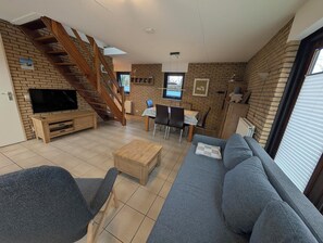 TV connectée, cheminée, livres, chaîne hi-fi