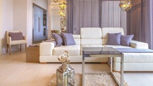 A modern living room with a white sofa, two armchairs, a glass coffee table, and decorative lighting. - Seafront Villa Prova 2***** with a top view, indoor & outdoor pool on Krk (Malinska)
