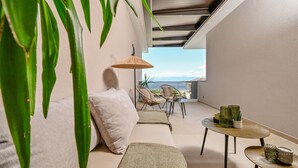 A balcony with a sofa, two wicker chairs, a small round table, and a hanging wicker umbrella. - Seafront Villa Prova 2***** with a top view, indoor & outdoor pool on Krk (Malinska)