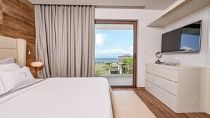 A modern hotel room with a large bed, a flat-screen TV, a sliding glass door to the balcony, and a minimalist design. - Seafront Villa Prova 2***** with a top view, indoor & outdoor pool on Krk (Malinska)