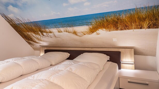 Een slaapkamer met uitzicht op het strand en de oceaan.
