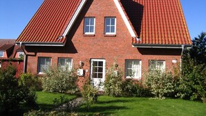 A red-brick house with a steeply pitched roof, a central door, and two windows on the upper floor. - North Friesland - In the Land of Horizons (Seeth)