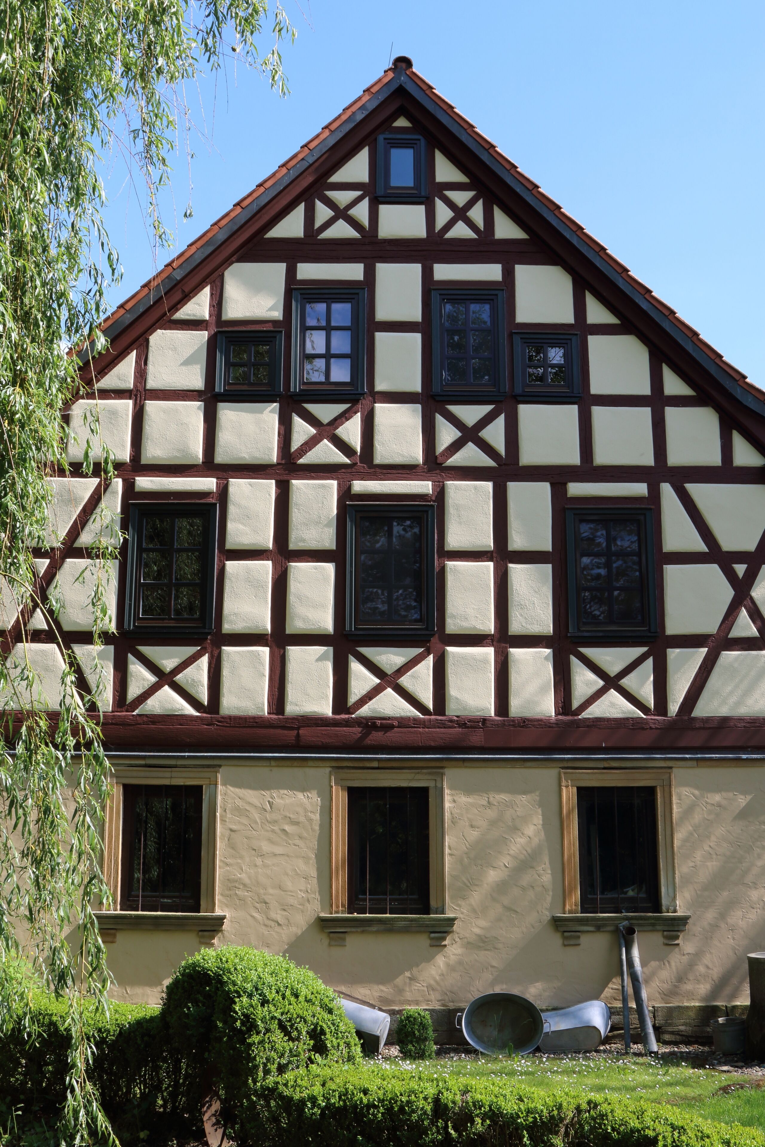 A traditional half-timbered house with multiple windows and a gabled roof.
