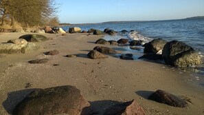 Ein Strand mit großen Felsen und freiem Blick auf das Meer.