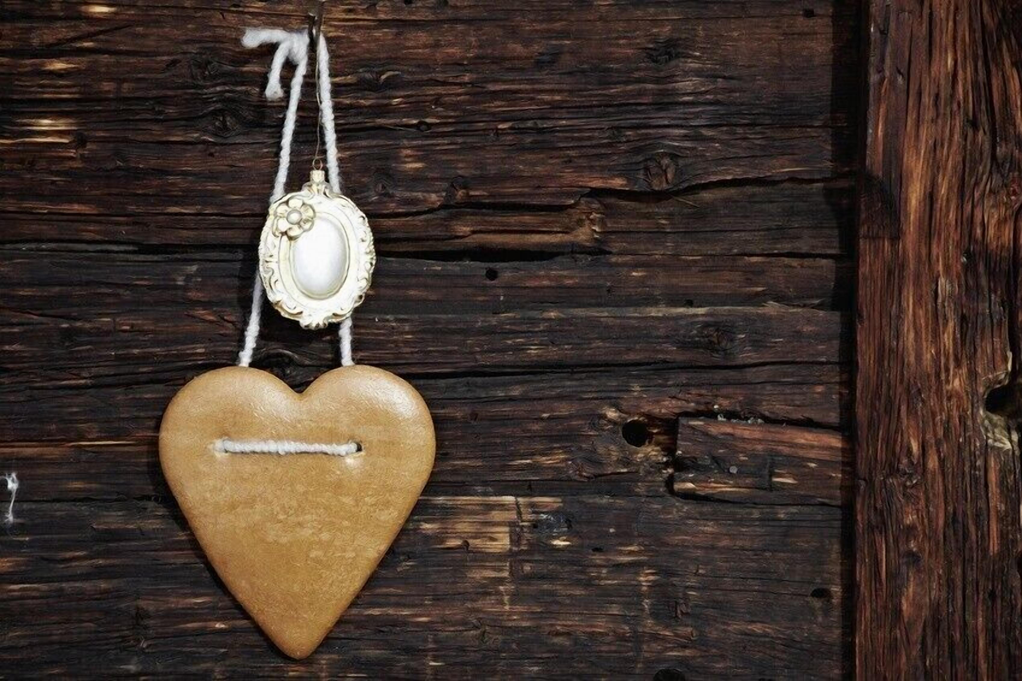 A heart-shaped cookie hanging on a wooden surface.