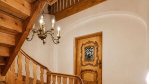 A wooden staircase with a handrail and a door with an ornate design. - Cozy, sunny & newly renovated apartment with a view of the Zugspitze - 4 stars (Garmisch - Partenkirchen)