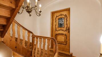 A wooden staircase with a handrail and a door with an ornate design.