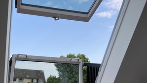A skylight window with a clear view of the sky and surrounding buildings. - EXCLUSIVE APARTMENT CENTER NOW (Celle)