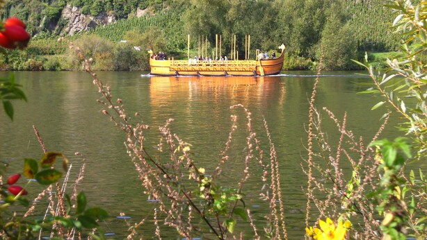 Um barco amarelo em um rio, cercado por vegetação.