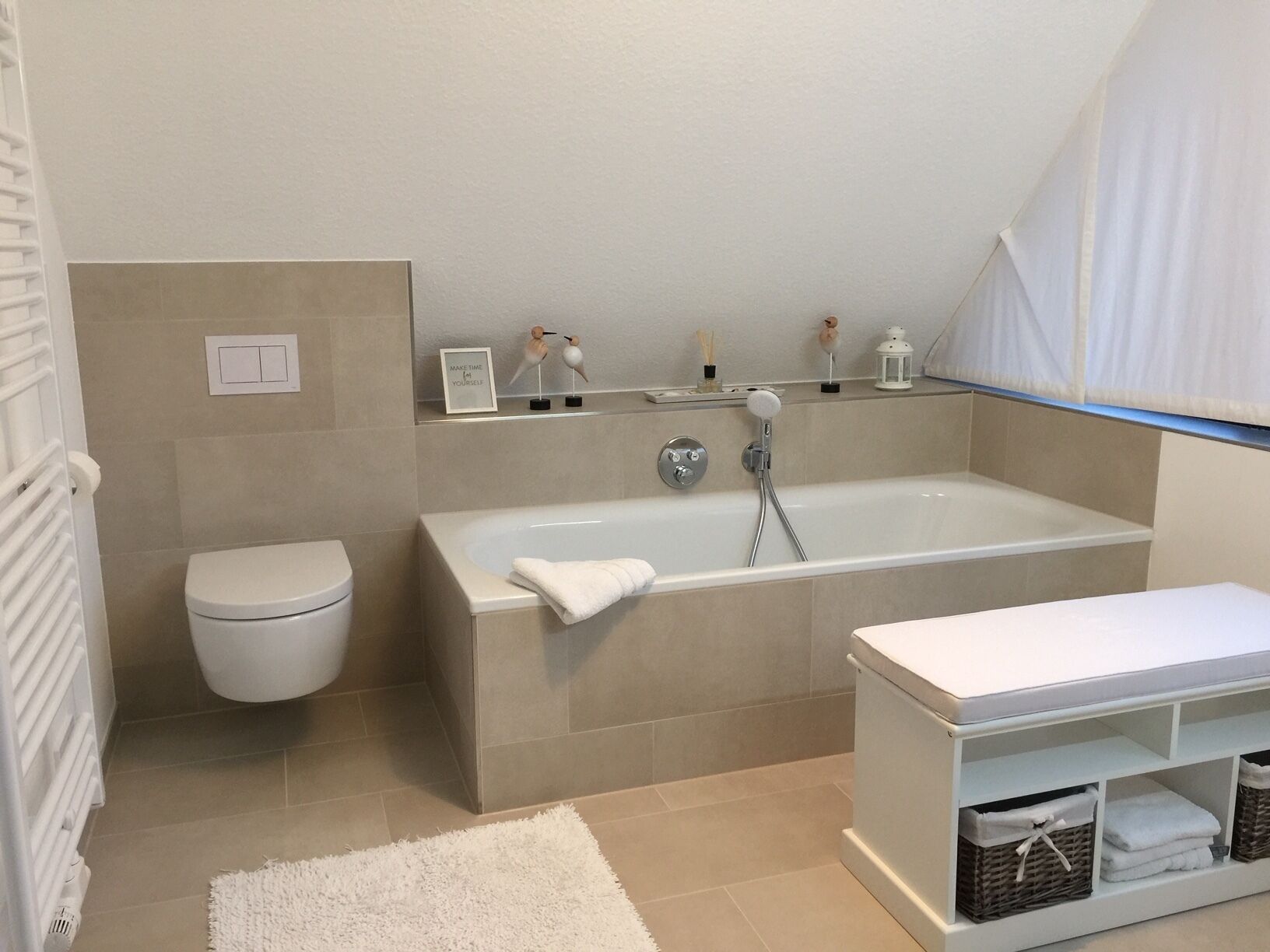 Un baño moderno con bañera, inodoro y zona de lavabo en blanco.