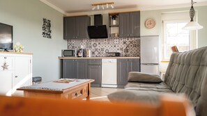 A modern kitchen with grey cabinets, a microwave, a dishwasher, and a refrigerator.