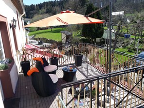 A balcony with outdoor furniture, a grill, and a view of a green landscape. - Take a few days blue, in the holiday home Blue (Berlingen)