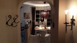 An interior view of a dining area with a table set for two, a chandelier, and a window with curtains. - Take a few days blue, in the holiday home Blue (Berlingen)