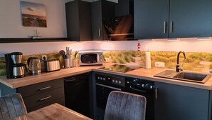 Una cocina moderna equipada con lavavajillas, microondas, cafetera y fregadero.