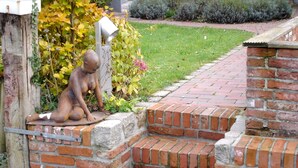 A brick wall with a statue of a child. - Studio apartment in restored captain's house with a panoramic view of the port (Krummhörn)