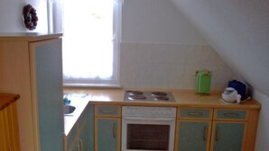 A compact kitchen with a stove, oven, and a window.