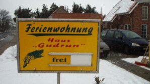 A yellow sign with black and red text advertising a property named "Feriendorfung Haus Gudrun".