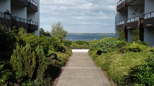 A pathway leading to a building with a view of the sea.