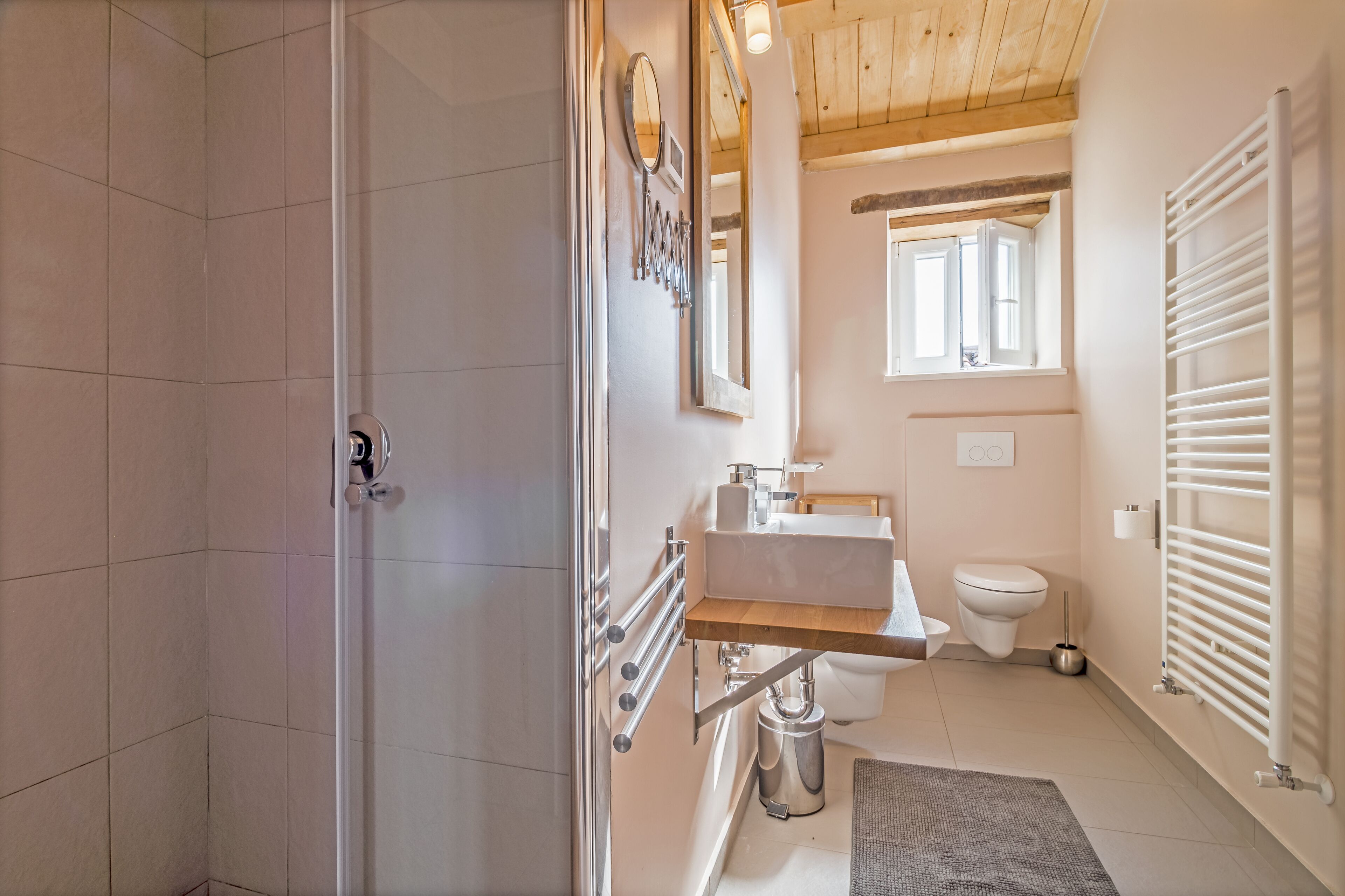Ein modernes Badezimmer mit Dusche, Toilette, Waschbecken und einem Fenster für natürliches Licht.