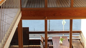 A wooden balcony with a view of a body of water and buildings in the background. - Sunny, east and south situated comfortable 4-room apartment. (Kühlungsborn)