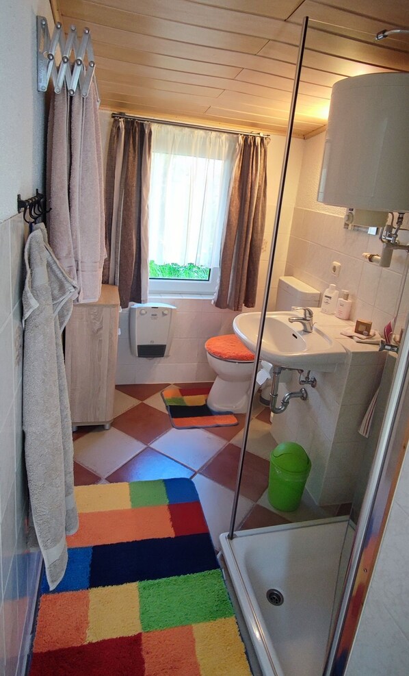 A bathroom with a shower, toilet, and sink.