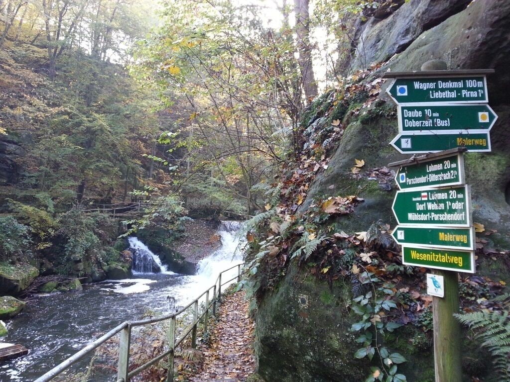 Un panneau indicateur indiquant les directions vers différentes destinations, notamment le monument Wagner, Daube et Lohmen.