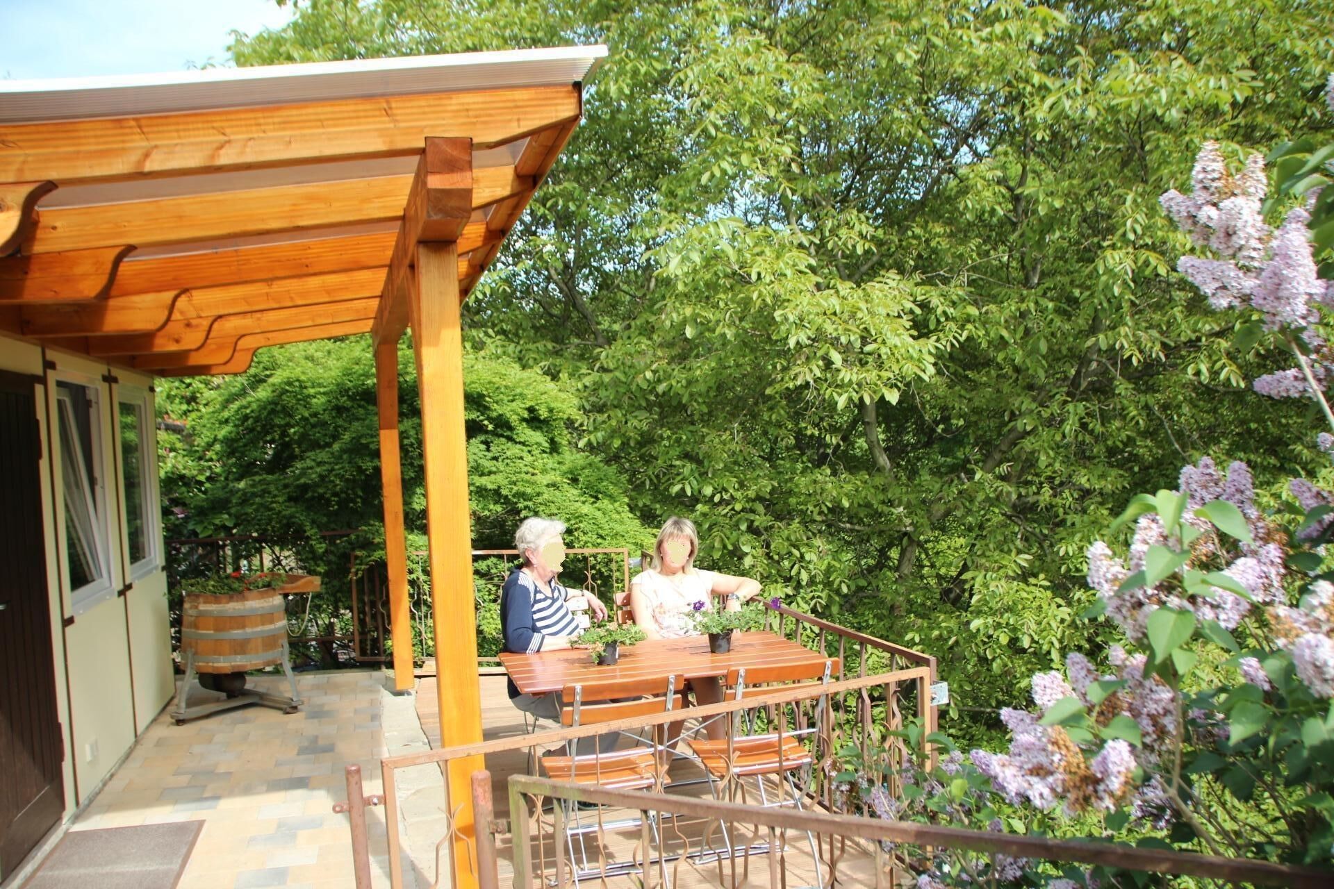 Un espace extérieur aménagé en terrasse, avec des meubles en bois et une structure en forme de pergola.