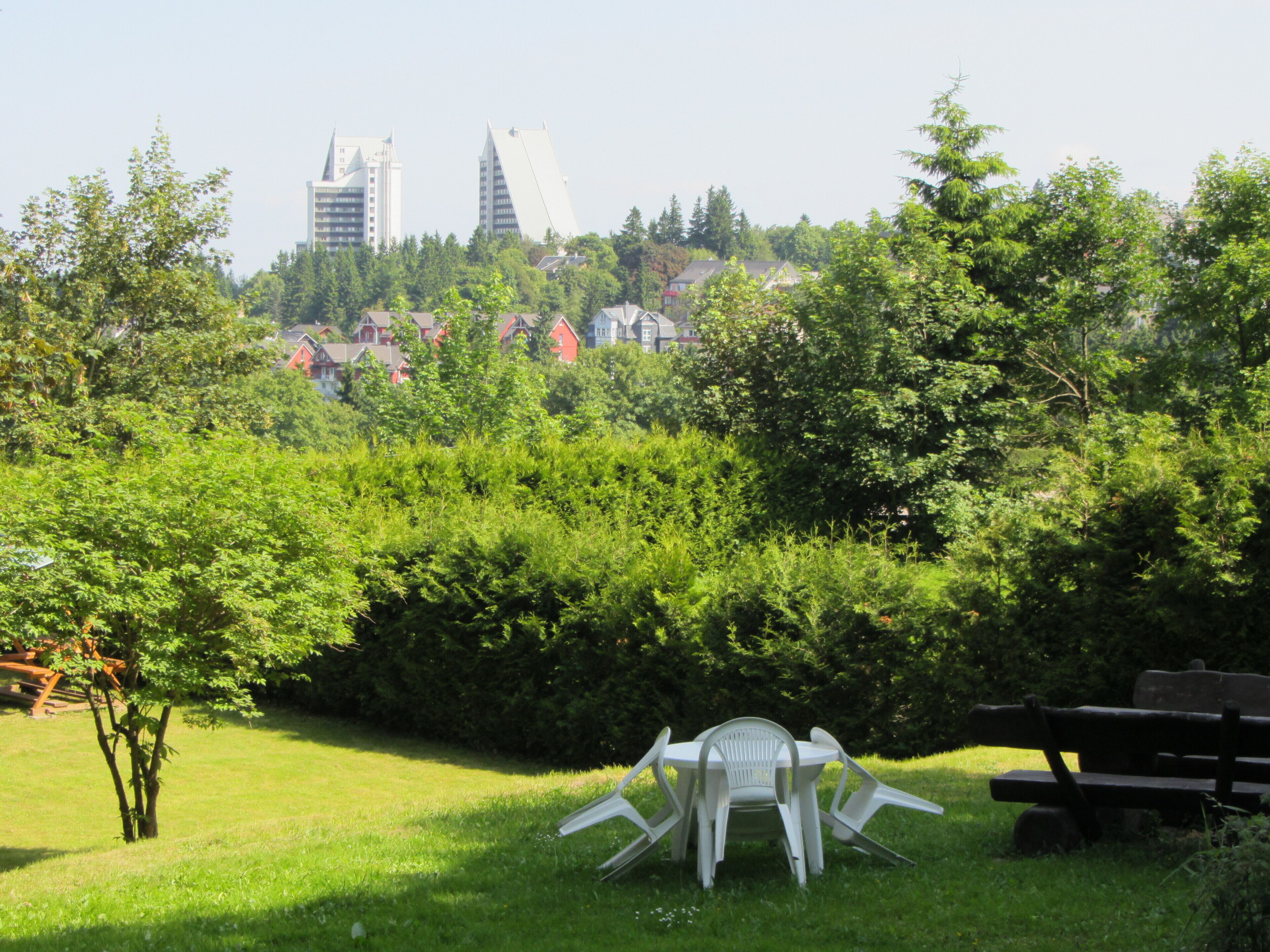 Un parc avec une chaise en plastique blanche et un banc.