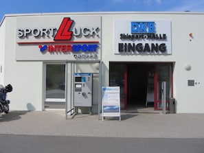 A building with signs for 'Sport Luck InterSport Gruppe' and 'DKB Skisport-Halle EINGANG'. - Holidays in Oberhof -. Thuringia ski No. 1 next to the Rennsteig (Oberhof)