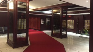 A lobby with a red carpet, wooden paneling, and glass display cases. - Private residence (Timmendorfer Strand)