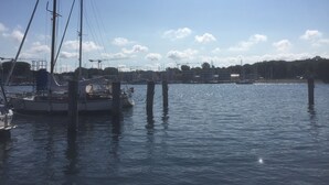 A marina with boats docked, a clear sky, and construction cranes in the background. - Private residence (Timmendorfer Strand)