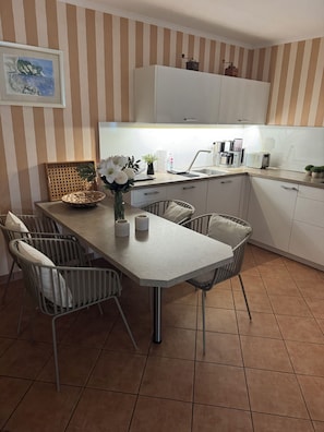 Eine moderne Küche mit Esstisch, Stühlen und Spüle.