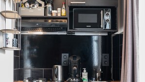 Une cuisine moderne équipée d’un four à micro-ondes, d’une machine à café et d’une bouilloire.