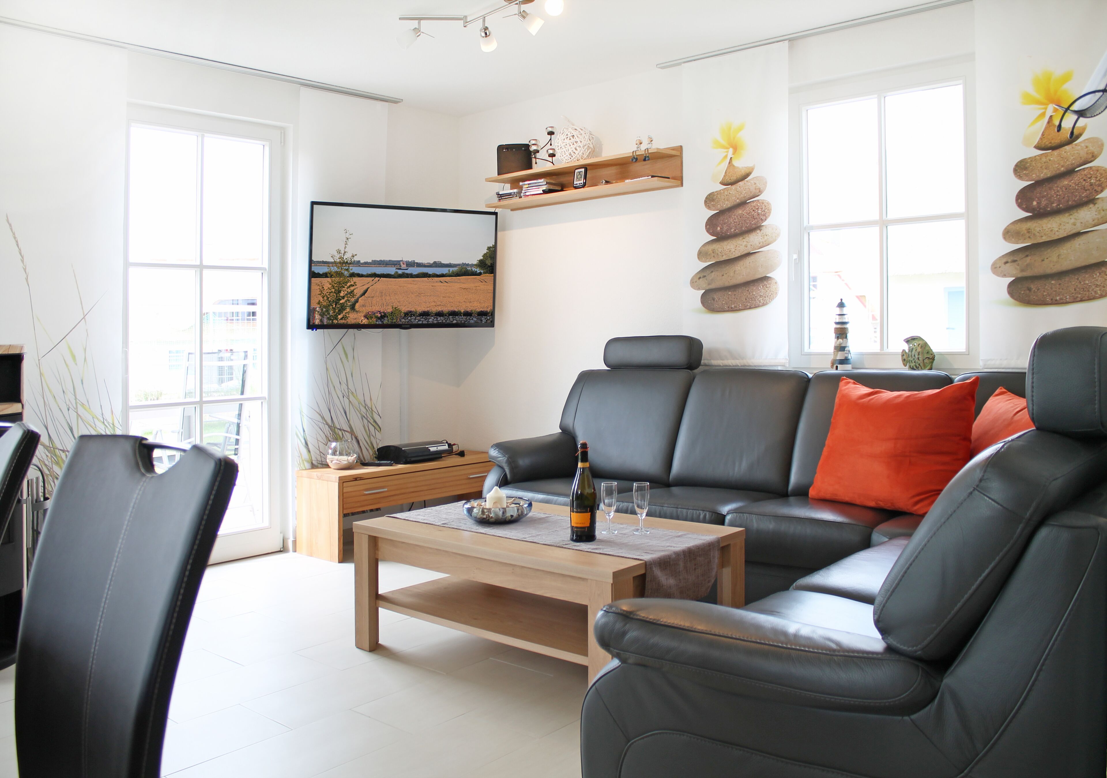 Ein modernes Wohnzimmer mit einer Ledersofa, einem Holztisch und einem flachbildfernseher an der Wand.