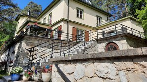A two-story building with a stone staircase leading to a balcony.