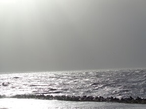 Une plage avec des vagues et un ciel dégagé.