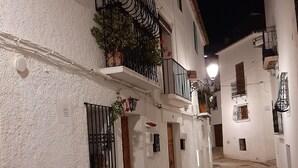 A narrow, cobblestone street flanked by white buildings with balconies, some with plants. - HOLIDAY HOUSE DIRECTLY BY THE SEA (Oliva Playa)